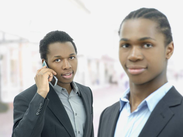 african american business partners looking at camera and calling with mobile  - Zdjęcie, obraz