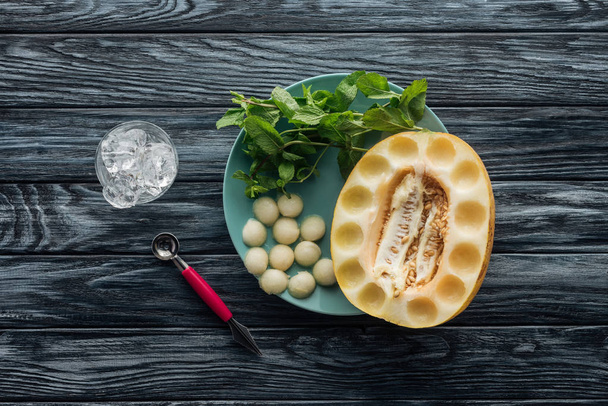 nane, buz küpleri ve lezzetli kavun topları ile tatlı Olgun kavun üstten görünüm ahşap yüzey üzerinde - Fotoğraf, Görsel