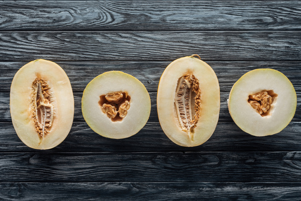 vista superior de melões maduros cortados pela metade na superfície de madeira
  - Foto, Imagem