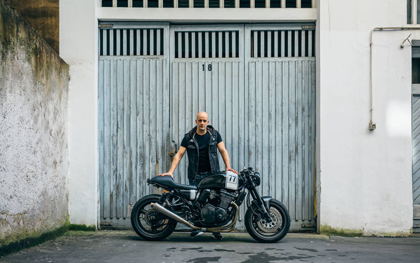 Builder posing with a motorcycle - Photo, Image