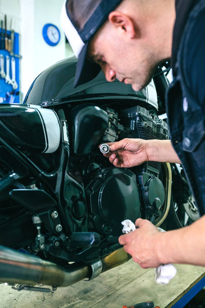 Mechanic repairing customized motorcycle - Photo, Image