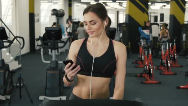 Attractive fit girl jogging in gym - Materiał filmowy, wideo