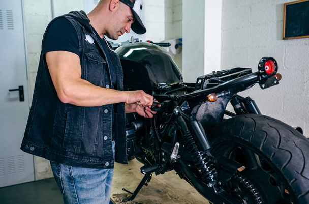 Механик мотоцикла меняет предохранитель
 - Фото, изображение