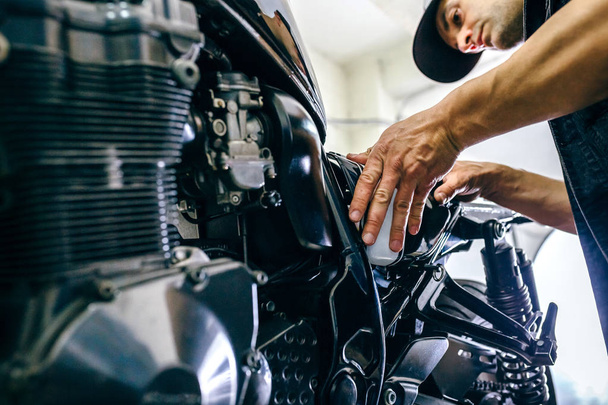 Mechanic repairing customized motorcycle - 写真・画像