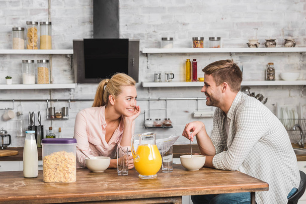 couple having breakfast in kitchen, girlfriend holding newspaper - Photo, Image