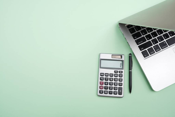 Flat lay,Top view office table desk. Workspace with calculator, black pen , laptop on the indigo Green background.Copy Space for text,Empty Blank to word.Business Finance,Education Technology Concept. - Foto, Imagem