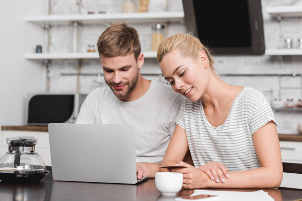 smiling young couple with credit card using laptop at home - Photo, Image