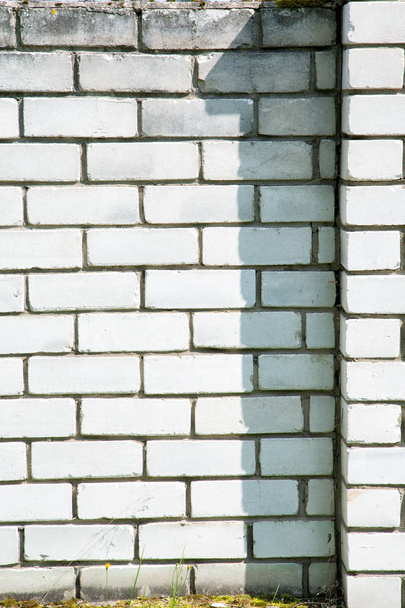 figure one shadow on a gray brick fence - Φωτογραφία, εικόνα