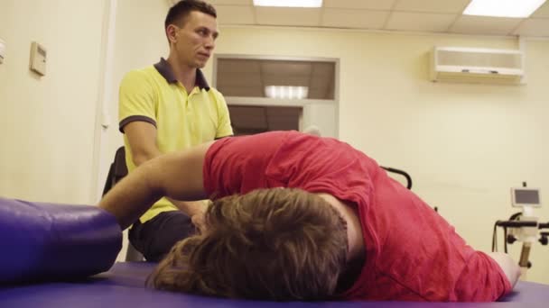 Portrét lékaře dělat cvičení pro zdravotně postižené muže - Záběry, video