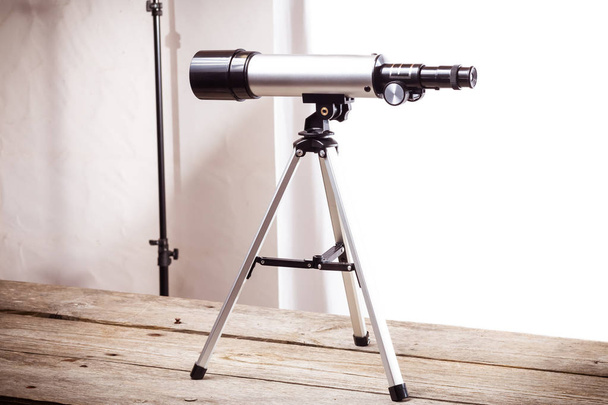 dalekohled na bílém pozadí na hrubé dřevěné desce - Fotografie, Obrázek