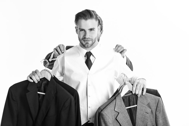 Businessman chooses outfit with hands of assistant behind him - Fotografie, Obrázek