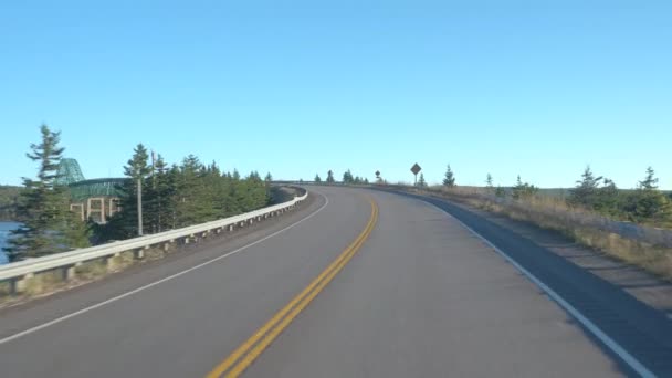 Zbliżenie: Przejście przez most wyspa uszczelnienie jazdy wzdłuż autostrady Transkanadyjskiej w słoneczny dzień. Osób na podróż pozostawiając Boularderie Island, podróży w kierunku Cape Breton, Nowa Szkocja, Kanada - Materiał filmowy, wideo