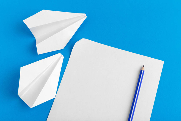 Flat lay of a paper plane on pastel blue color background - Foto, Imagen