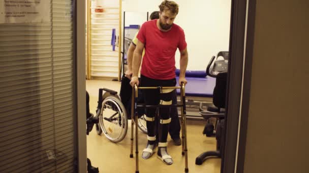 Homme handicapé en orthèse marchant tenant un cadre de marche
 - Séquence, vidéo