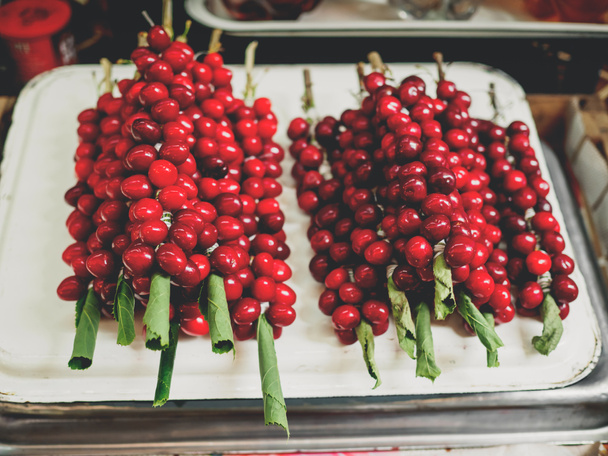 グルジアの市場でぶどうの葉に赤い熟した tkemali 梅 - 写真・画像