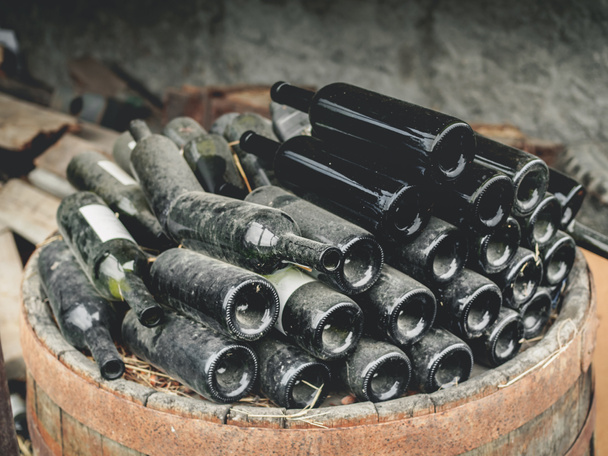 primer plano de botellas de vino usadas sucias vacías en pila en barril de madera en Georgia
 - Foto, Imagen