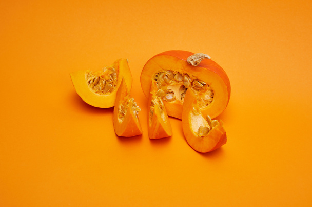 オレンジ色の背景に熟したスライスしたカボチャの種子のクローズ アップ ビュー    - 写真・画像