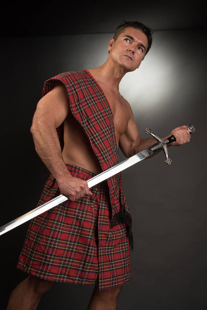 Sexy highlander podnosi miecz. - Zdjęcie, obraz