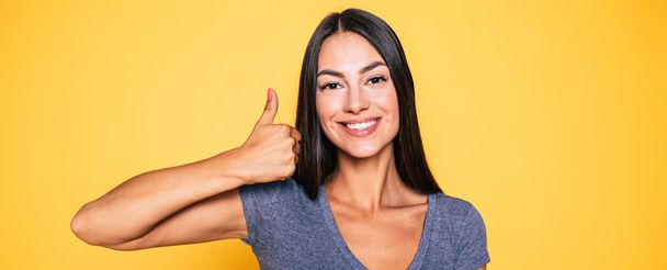 Portrait of smiling brunette showing ok sign - Фото, изображение