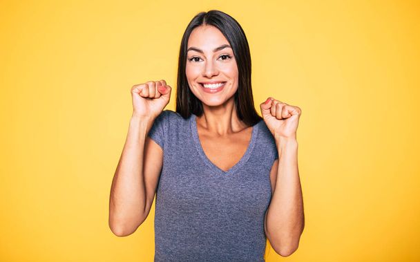 Funny smiling hapy brunette on yellow background - Foto, Bild