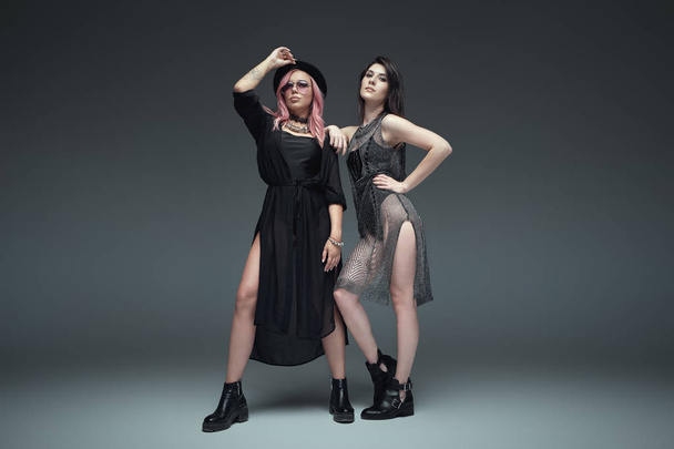 Две модные девушки в черных модных нарядах позируют
 - Фото, изображение