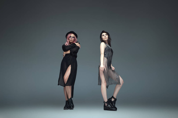 Two fashionable girls wearing black trendy outfits posing - Foto, Imagen