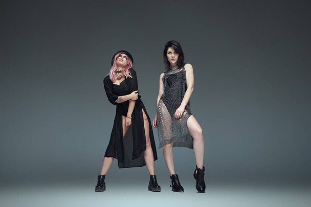 Two fashionable girls wearing black trendy outfits posing - Photo, Image