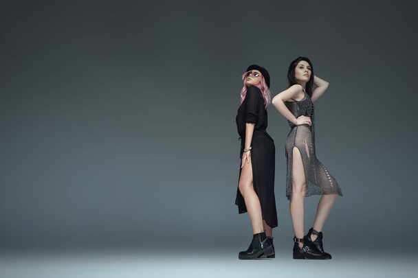 Two fashionable girls wearing black trendy outfits posing - Foto, afbeelding