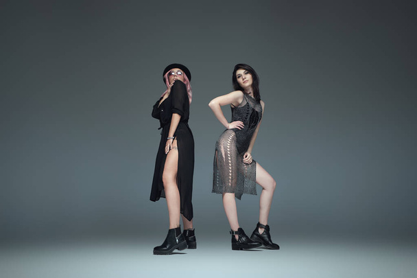 Two fashionable girls wearing black trendy outfits posing - Фото, изображение