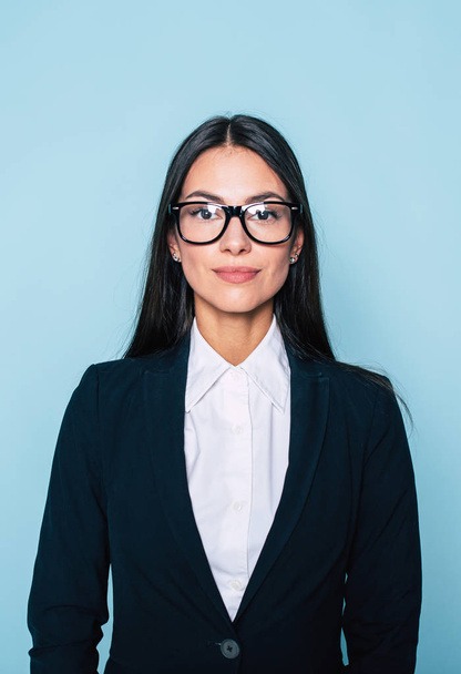 Portrait of young businesswoman posing on blue background - Foto, Imagem