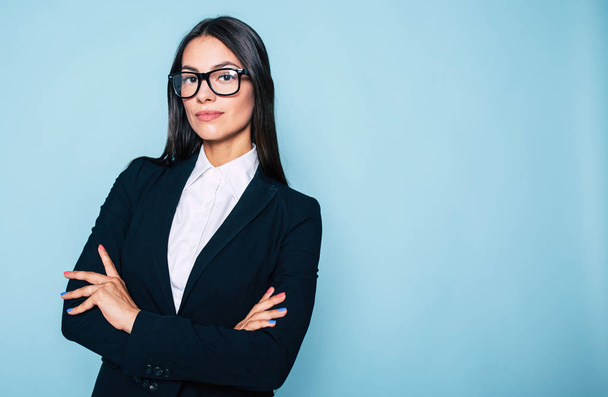 Portrait of young businesswoman posing on blue background - Фото, зображення