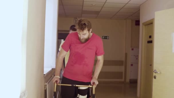 Gezicht van gehandicapte man in orthese wandelen met een wandelende frame - Video