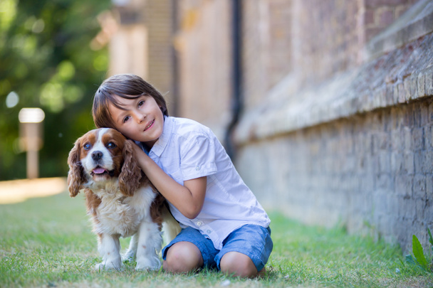 Beaugtiful preschool children, playing with sweet dog in the park, summertime - Foto, Imagen