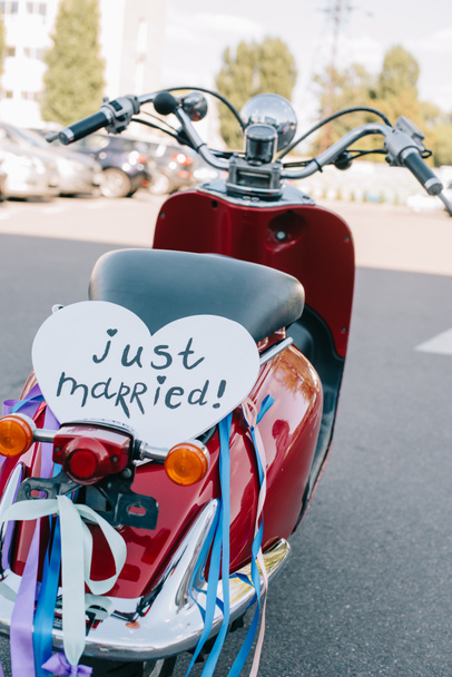 scooter vintage vermelho com fitas e símbolo de coração "recém-casado" para o casamento
 - Foto, Imagem