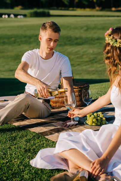 bello sposo versando il vino nel bicchiere per la giovane sposa su picnic
 - Foto, immagini