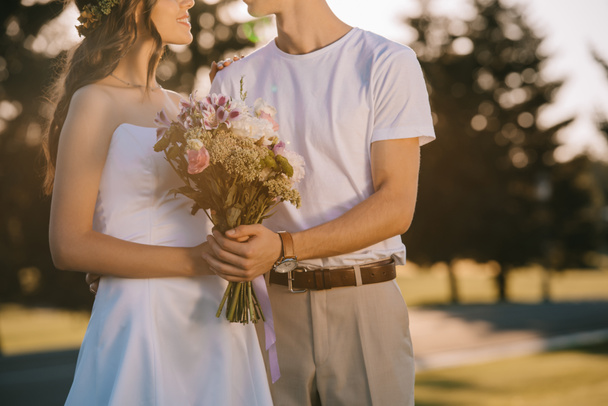 cropped view of wedding couple holding flower bouquet - Photo, Image