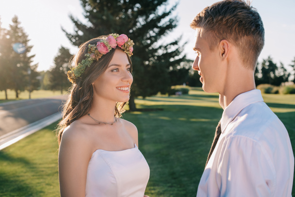 beautiful happy young wedding couple looking at each other in park - Foto, Imagem