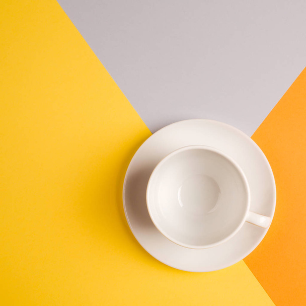 white empty coffee Cup on bright yellow-orange-beige-gray background. copy spase, flat lay. concept of autumn cafe menu - Foto, afbeelding