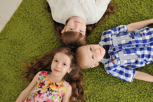 Children in the children's room lie on the carpet. - Foto, Bild