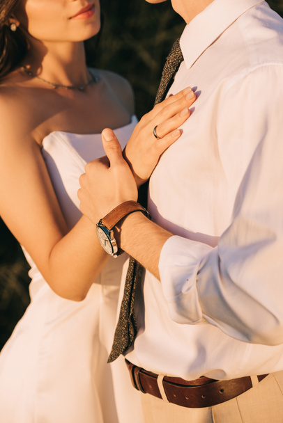 cropped shot of loving young wedding couple embracing and holding hands  - Фото, изображение