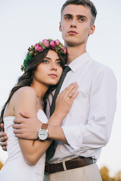 beautiful romantic young wedding couple embracing and looking away - 写真・画像