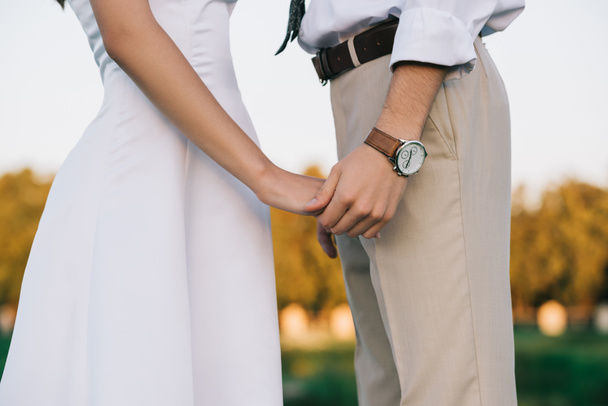 cropped shot of romantic young wedding couple holding hands - Foto, Imagem