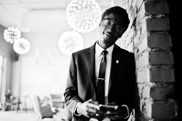 Business african american man wear on black suit and glasses at office looking on mobile phone. - Fotografie, Obrázek