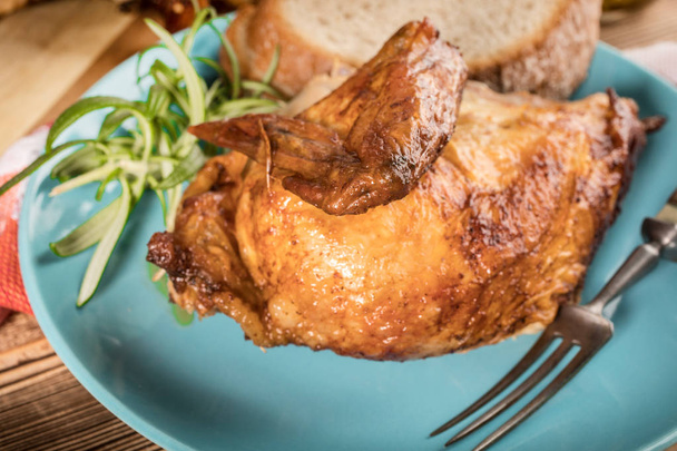 Pieces of roast chicken on a blue plate. - Фото, зображення