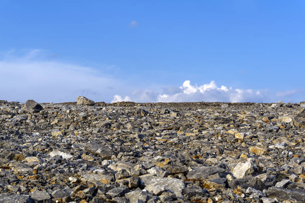 deserted flat gravelly rocky terrain under the sky - Zdjęcie, obraz