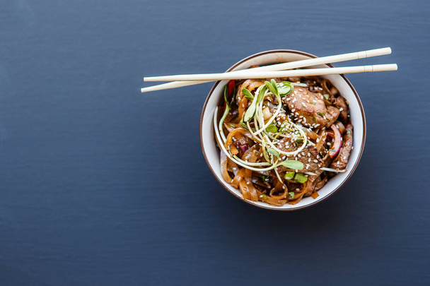 Une assiette de nouilles de bœuf wok
 - Photo, image