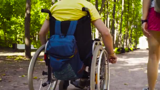 Bir tekerlekli sandalye ve kadının bacakları yürüyüş sırasında tekerlekleri - Video, Çekim