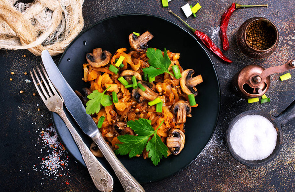  Vegan dish. Fried mushrooms and cabbage in the frying pan. European cuisine. - Foto, afbeelding