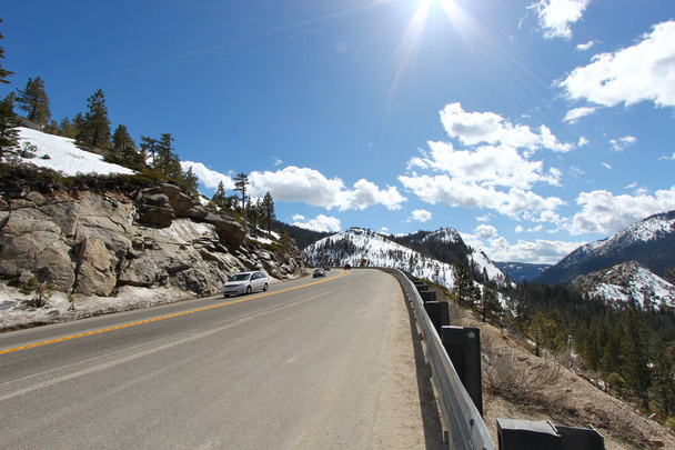 Un camino al lago Tahoe con montañas cubiertas de nieve
. - Foto, imagen