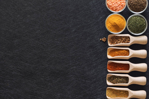 Herbs, spices and food additives on a dark background with an empty place - Foto, Imagen